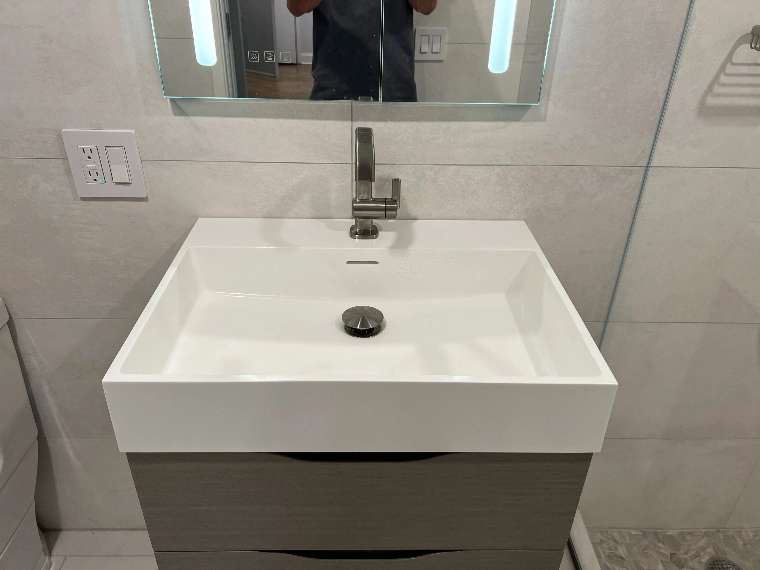 Modern white bathroom sink with wall-mounted faucet