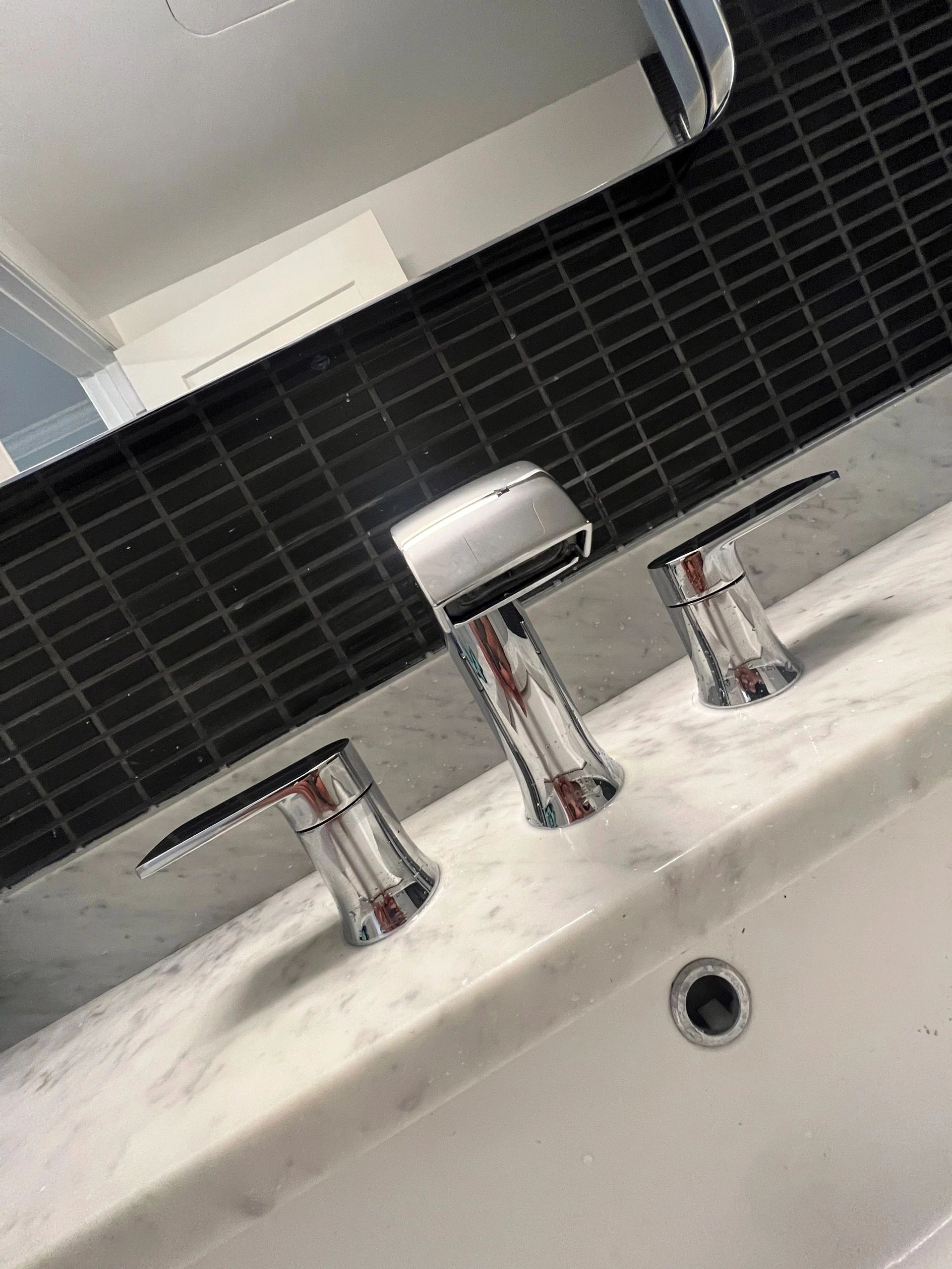Chrome faucet against black tile
